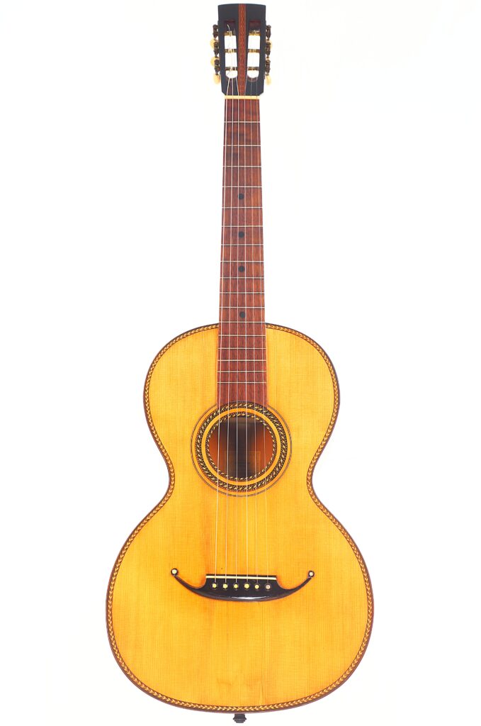 Die Marc Antonio Romantikgitarre ist eine klassische Akustikgitarre mit einem Korpus aus hellem Holz, einem Hals aus dunklem Holz und einer dekorativen Rosette um das Schallloch, fotografiert vor einem weißen Hintergrund. Die Marc Antonio Romantikgitarre ist eine klassische Akustikgitarre mit einem Korpus aus hellem Holz, einem Hals aus dunklem Holz und einer dekorativen Rosette um das Schallloch, fotografiert vor einem weißen Hintergrund.