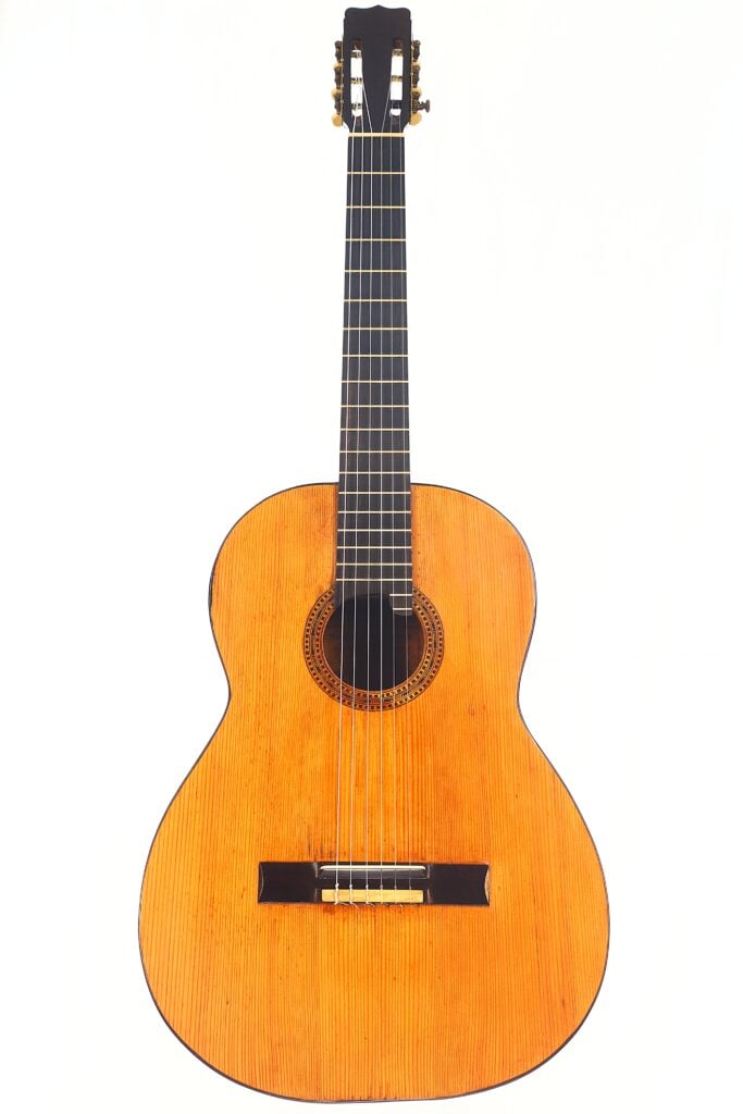 Die Juan Lopez Jimenez 1933 Klassische Gitarre, eine klassische akustische Gitarre mit Holzkorpus, dunklem Griffbrett und sechs Saiten, ist vor einem schlichten weißen Hintergrund fotografiert. Die Juan Lopez Jimenez 1933 Klassische Gitarre, eine klassische akustische Gitarre mit Holzkorpus, dunklem Griffbrett und sechs Saiten, ist vor einem schlichten weißen Hintergrund fotografiert.