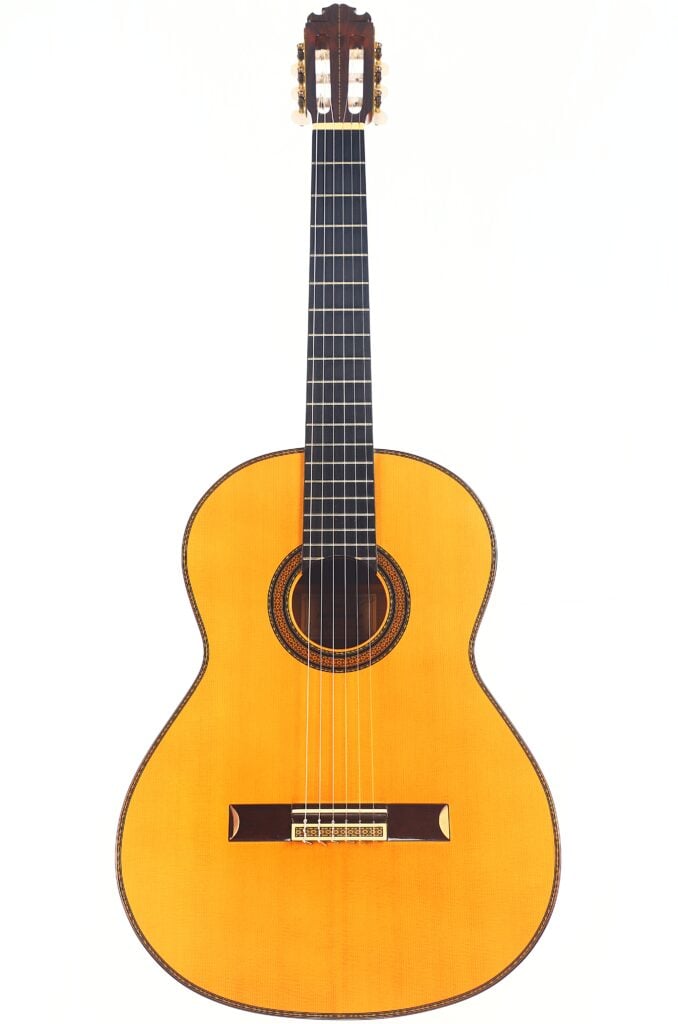 Die Manuel Contreras Double Top 1985 Klassische Gitarre, eine klassische Akustikgitarre mit hellem Holzkorpus und dunklem Griffbrett, sechs Saiten, wird vor einem einfachen weißen Hintergrund gezeigt. Die Manuel Contreras Double Top 1985 Klassische Gitarre, eine klassische Akustikgitarre mit hellem Holzkorpus und dunklem Griffbrett, sechs Saiten, wird vor einem einfachen weißen Hintergrund gezeigt.