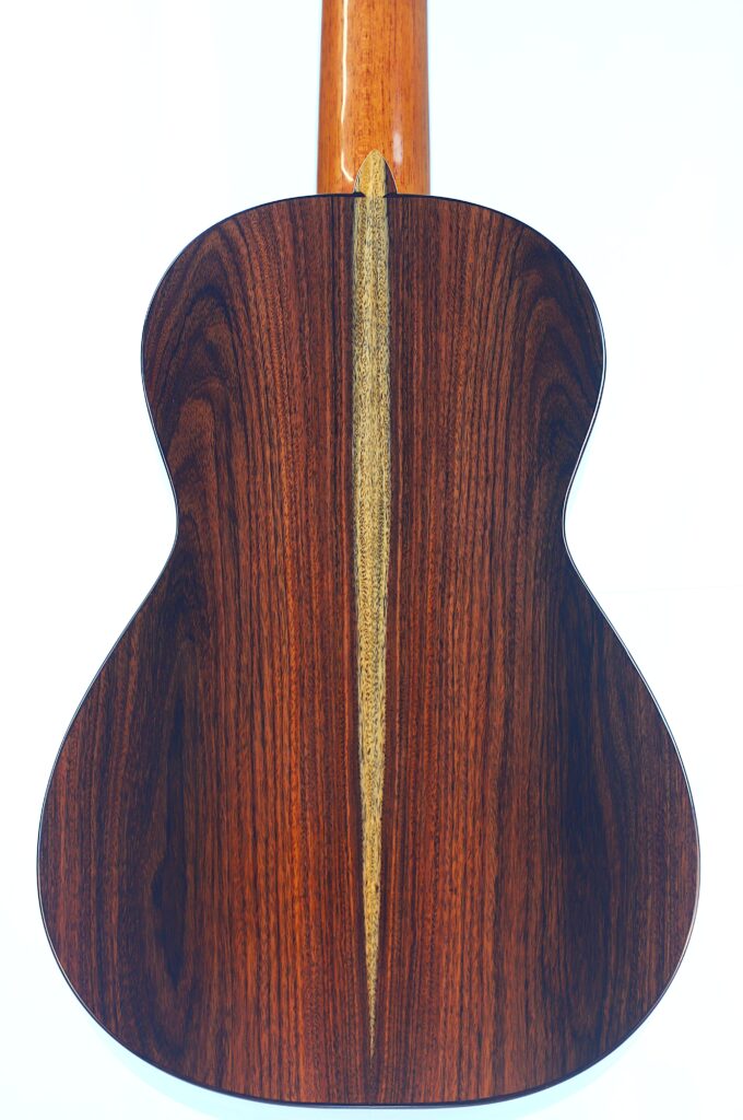 Die Jellinghaus Torres 77 PU Klassische Gitarre hat einen polierten Boden aus dunklem Holz, der durch einen auffälligen hellen Mittelstreifen hervorgehoben wird, der vertikal in der Mitte verläuft. Die Jellinghaus Torres 77 PU Klassische Gitarre hat einen polierten Boden aus dunklem Holz, der durch einen auffälligen hellen Mittelstreifen hervorgehoben wird, der vertikal in der Mitte verläuft.