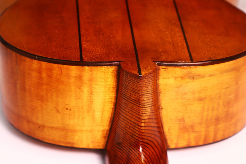 Nahaufnahme der Rückseite der Juan Lopez Jimenez 1933 Klassische Gitarre. Hervorzuheben sind die glatte, polierte Holzmaserung und die fachmännisch gefertigte Halsverbindung in satten, warmen Brauntönen. Nahaufnahme der Rückseite der Juan Lopez Jimenez 1933 Klassische Gitarre. Hervorzuheben sind die glatte, polierte Holzmaserung und die fachmännisch gefertigte Halsverbindung in satten, warmen Brauntönen.