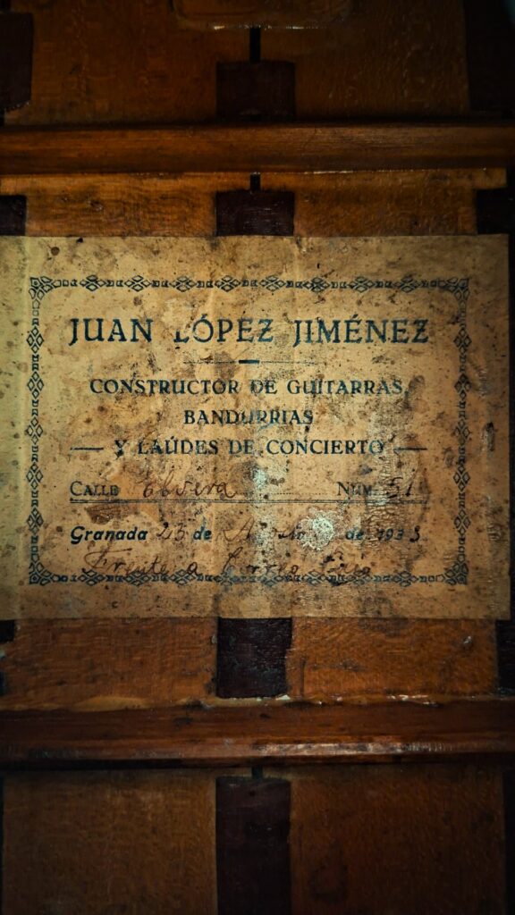 Auf einem abgenutzten Etikett im Inneren der Juan Lopez Jimenez 1933 Klassische Gitarre steht "Juan López Jiménez, Constructor de Guitarras, Bandurrias y Laúdes de Concierto, Granada" mit handschriftlichen Angaben wie Straße, Nummer 51 und Jahr 1935. Auf einem abgenutzten Etikett im Inneren der Juan Lopez Jimenez 1933 Klassische Gitarre steht "Juan López Jiménez, Constructor de Guitarras, Bandurrias y Laúdes de Concierto, Granada" mit handschriftlichen Angaben wie Straße, Nummer 51 und Jahr 1935.