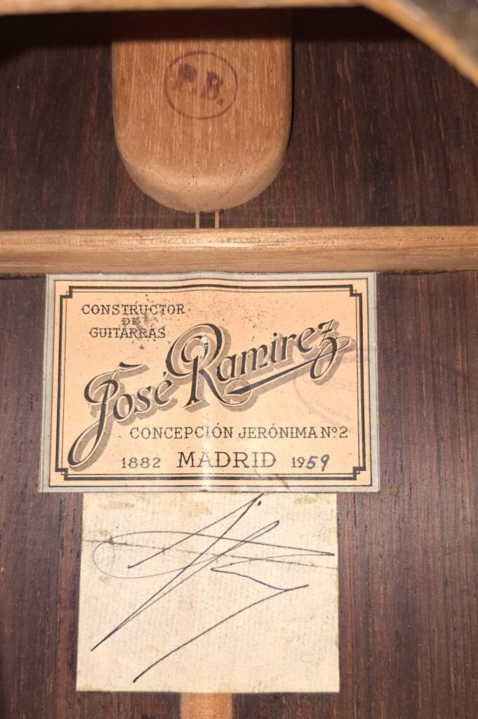 Eine Nahaufnahme zeigt das Etikett im Inneren einer Jose Ramirez 1a 1959 PB Klassische Gitarre mit der Aufschrift "José Ramírez, Constructor de Guitarras, Concepción Jerónima Nº2, 1882 Madrid 1959", darunter eine handschriftliche Unterschrift. Eine Nahaufnahme zeigt das Etikett im Inneren einer Jose Ramirez 1a 1959 PB Klassische Gitarre mit der Aufschrift "José Ramírez, Constructor de Guitarras, Concepción Jerónima Nº2, 1882 Madrid 1959", darunter eine handschriftliche Unterschrift.