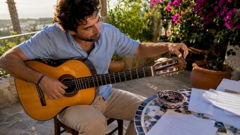 Guitarist tuning flamenco guitar indoors
