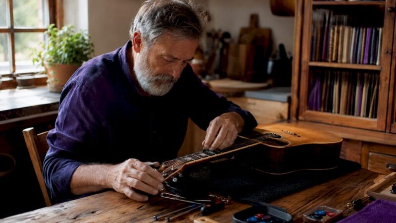 Luthier tuning vintage acoustic guitar