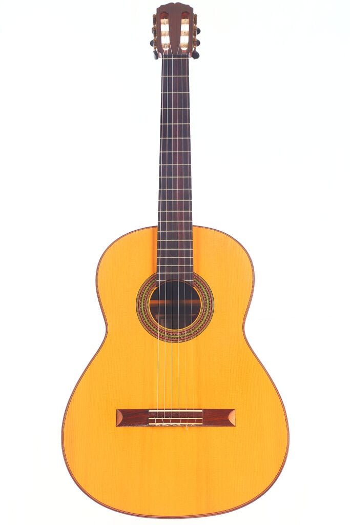 Die „Carl Hermann Schäfer – Nicolaus Wollf 2012 Klassische Gitarre“ ist eine klassische Akustikgitarre mit einem hellen Korpus, einem dunklen Griffbrett und sechs Saiten, die vor einem schlichten weißen Hintergrund abgebildet ist. Die „Carl Hermann Schäfer – Nicolaus Wollf 2012 Klassische Gitarre“ ist eine klassische Akustikgitarre mit einem hellen Korpus, einem dunklen Griffbrett und sechs Saiten, die vor einem schlichten weißen Hintergrund abgebildet ist.