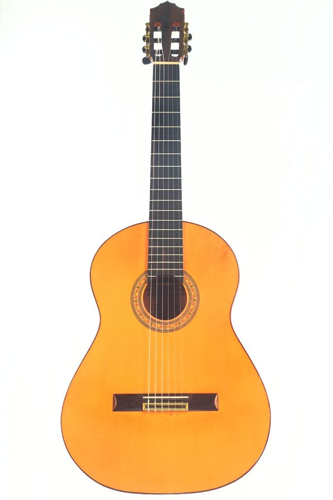 Die José M Palmero 2023 Flamenco-Gitarre verfügt über einen hellen Holzkorpus, ein dunkles Griffbrett und sechs Saiten und ist auf einem Foto vor einem schlichten weißen Hintergrund zu sehen. Die José M Palmero 2023 Flamenco-Gitarre verfügt über einen hellen Holzkorpus, ein dunkles Griffbrett und sechs Saiten und ist auf einem Foto vor einem schlichten weißen Hintergrund zu sehen.