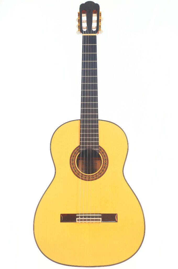 Die Vicente Carrillo 1998 Torres Klassische Gitarre ist eine klassische Akustikgitarre mit einem hellen Holzkorpus, einem dunklen Griffbrett und sechs Saiten auf einem schlichten weißen Hintergrund. Die Vicente Carrillo 1998 Torres Klassische Gitarre ist eine klassische Akustikgitarre mit einem hellen Holzkorpus, einem dunklen Griffbrett und sechs Saiten auf einem schlichten weißen Hintergrund.
