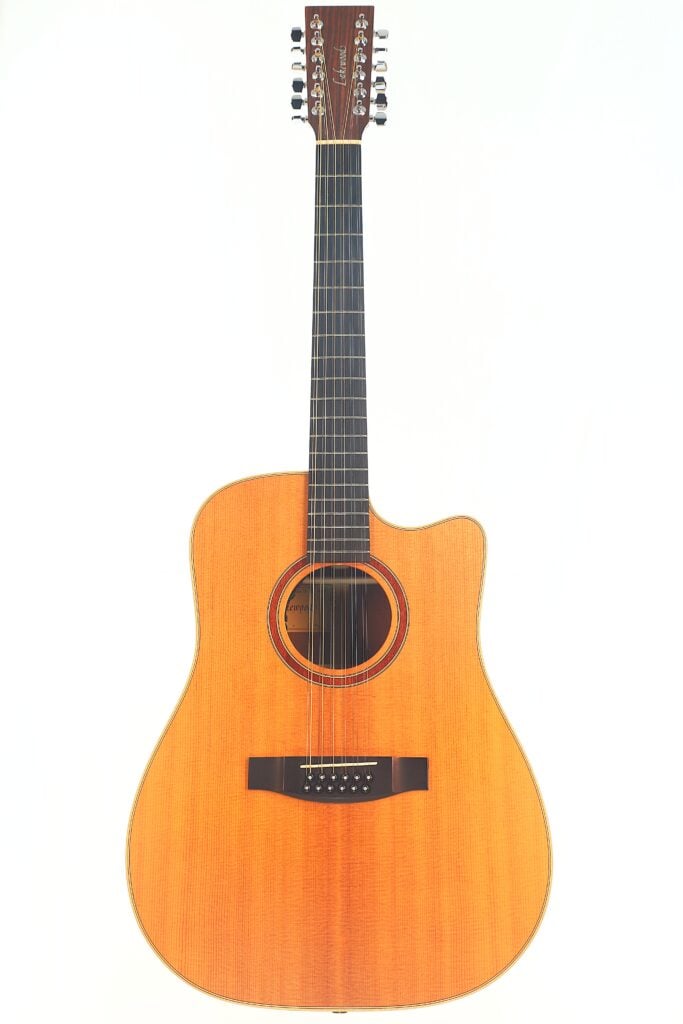 Die Lakewood D-14-12 Cut 2005 Akustik Gitarre ist eine 12-saitige Akustikgitarre mit natürlichem Holzfinish, Cutaway-Korpus und dunklen Stimmwirbeln, die vor einem schlichten weißen Hintergrund abgebildet sind. Die Lakewood D-14-12 Cut 2005 Akustik Gitarre ist eine 12-saitige Akustikgitarre mit natürlichem Holzfinish, Cutaway-Korpus und dunklen Stimmwirbeln, die vor einem schlichten weißen Hintergrund abgebildet sind.
