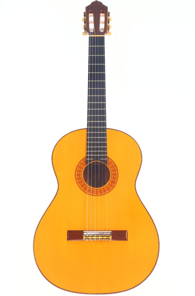 Die Juan Montero 1993 Blanca Flamenco Gitarre ist eine klassische Akustikgitarre mit hellem Holzkorpus, dunklem Griffbrett und sechs Saiten, die auf einem schlichten weißen Hintergrund abgebildet ist. Die Juan Montero 1993 Blanca Flamenco Gitarre ist eine klassische Akustikgitarre mit hellem Holzkorpus, dunklem Griffbrett und sechs Saiten, die auf einem schlichten weißen Hintergrund abgebildet ist.