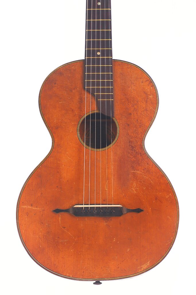 Die Braun & Hauser 1905 Klassische Gitarre ist eine Akustikgitarre im Vintage-Stil mit Holzkorpus, sechs Saiten, rundem Schallloch und dunklem Steg, die vor einem weißen Hintergrund steht. Die Braun & Hauser 1905 Klassische Gitarre ist eine Akustikgitarre im Vintage-Stil mit Holzkorpus, sechs Saiten, rundem Schallloch und dunklem Steg, die vor einem weißen Hintergrund steht.