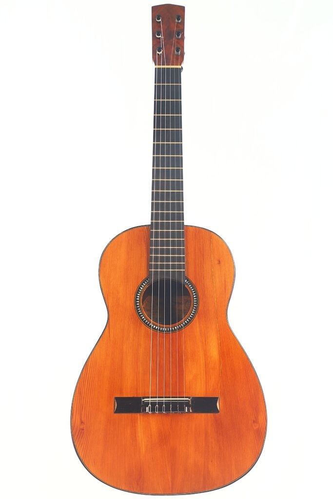 Die Andres Marin 1890 Klassische Gitarre ist eine klassische Akustikgitarre mit einem Holzkorpus, sechs Saiten und einem dunklen Griffbrett, das vor einem schlichten weißen Hintergrund abgebildet ist. Die Andres Marin 1890 Klassische Gitarre ist eine klassische Akustikgitarre mit einem Holzkorpus, sechs Saiten und einem dunklen Griffbrett, das vor einem schlichten weißen Hintergrund abgebildet ist.