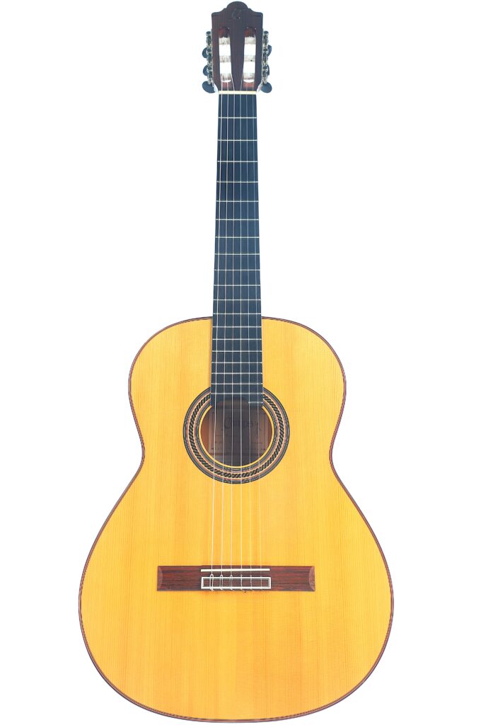 Die Camps Primera A 2018 Flamenco Gitarre verfügt über einen hellen Holzkorpus, ein dunkles Griffbrett und sechs Saiten und wird vor einem schlichten weißen Hintergrund präsentiert. Die Camps Primera A 2018 Flamenco Gitarre verfügt über einen hellen Holzkorpus, ein dunkles Griffbrett und sechs Saiten und wird vor einem schlichten weißen Hintergrund präsentiert.
