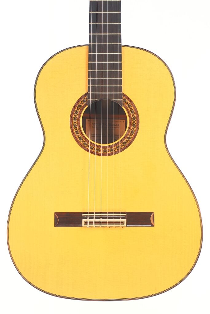 Die Vicente Carrillo 1998 Torres Klassische Gitarre hat einen hellen Holzkorpus, ein dunkles Griffbrett und eine dekorative Rosette um das Schallloch, fotografiert vor einem weißen Hintergrund. Die Vicente Carrillo 1998 Torres Klassische Gitarre hat einen hellen Holzkorpus, ein dunkles Griffbrett und eine dekorative Rosette um das Schallloch, fotografiert vor einem weißen Hintergrund.