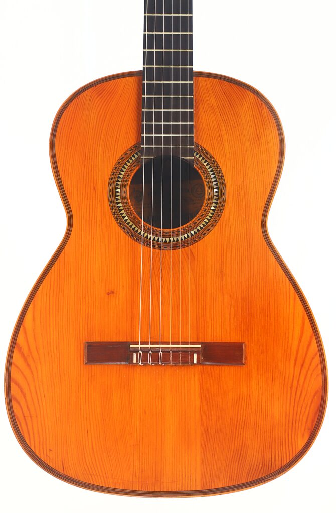 Die Andres Marin 1900 Klassische Gitarre ist eine klassische Akustikgitarre mit einem Holzkorpus, sechs Saiten und einer detaillierten Rosette um das Schallloch, abgebildet vor einem weißen Hintergrund. Die Andres Marin 1900 Klassische Gitarre ist eine klassische Akustikgitarre mit einem Holzkorpus, sechs Saiten und einer detaillierten Rosette um das Schallloch, abgebildet vor einem weißen Hintergrund.