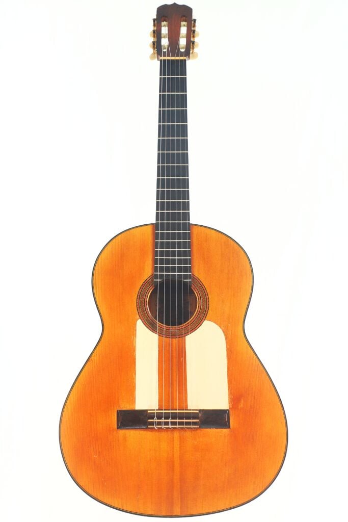 Die Jose Ramirez 1955 Flamenco Gitarre ist eine klassische Akustikgitarre mit einem Holzkorpus, sechs Saiten und einem hellen Griffbrett, die aufrecht vor einem schlichten weißen Hintergrund fotografiert wurde. Die Jose Ramirez 1955 Flamenco Gitarre ist eine klassische Akustikgitarre mit einem Holzkorpus, sechs Saiten und einem hellen Griffbrett, die aufrecht vor einem schlichten weißen Hintergrund fotografiert wurde.