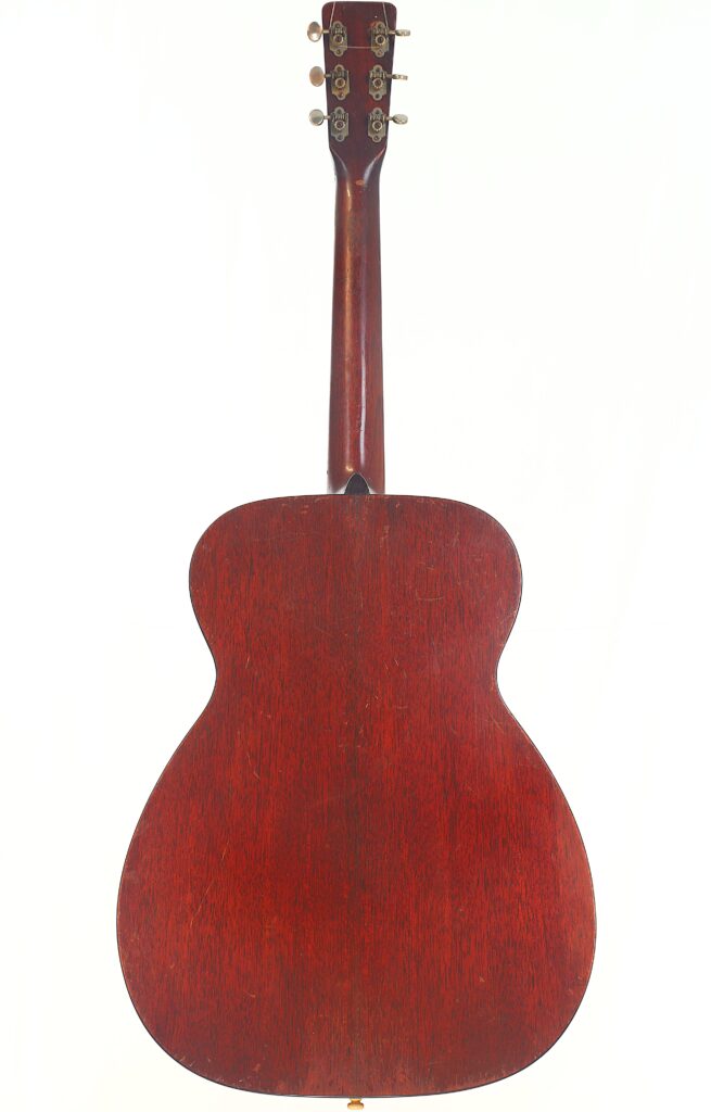 Das Bild zeigt die Rückseite einer Martin 00-18 Akustikgitarre aus dem Jahr 1954 mit einer satten, dunkelrotbraunen Holzoberfläche. Oben sind die Stimmwirbel und der Hals vor einem weißen Hintergrund zu sehen. Das Bild zeigt die Rückseite einer Martin 00-18 Akustikgitarre aus dem Jahr 1954 mit einer satten, dunkelrotbraunen Holzoberfläche. Oben sind die Stimmwirbel und der Hals vor einem weißen Hintergrund zu sehen.