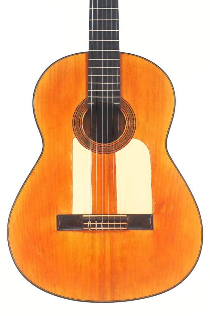 Die Jose Ramirez 1955 Flamenco Gitarre ist eine klassische Akustikgitarre mit einem Holzkorpus, schwarzem Griffbrett und sechs Saiten, die aufrecht vor einem weißen Hintergrund abgebildet ist. Die Jose Ramirez 1955 Flamenco Gitarre ist eine klassische Akustikgitarre mit einem Holzkorpus, schwarzem Griffbrett und sechs Saiten, die aufrecht vor einem weißen Hintergrund abgebildet ist.