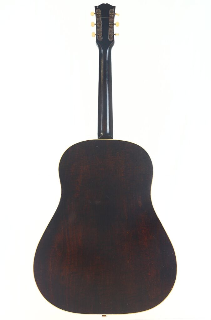 Das Bild zeigt die Rückansicht einer Gibson J-45 Banner 1944 Akustik Gitarre in Dunkelbraun mit glänzender Lackierung, klassischer Form, schmalem Hals und breitem, abgerundetem Korpus, vertikal vor einem schlichten weißen Hintergrund. Das Bild zeigt die Rückansicht einer Gibson J-45 Banner 1944 Akustik Gitarre in Dunkelbraun mit glänzender Lackierung, klassischer Form, schmalem Hals und breitem, abgerundetem Korpus, vertikal vor einem schlichten weißen Hintergrund.