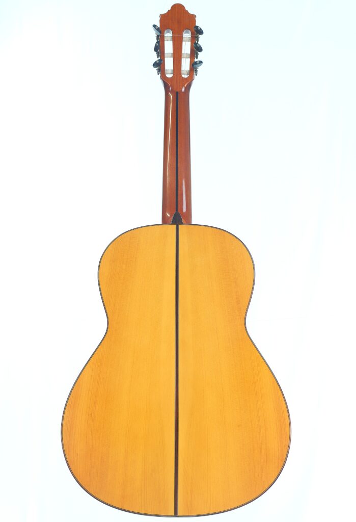 Die Flamenco-Gitarre „Camps Primera A 2018“ ist hier von hinten zu sehen: Sie verfügt über einen hellen Holzkorpus mit einer dunklen Mittelnaht sowie einen dunkelbraunen Hals und eine dunkelbraune Kopfplatte vor einem schlichten, hellen Hintergrund. Die Flamenco-Gitarre „Camps Primera A 2018“ ist hier von hinten zu sehen: Sie verfügt über einen hellen Holzkorpus mit einer dunklen Mittelnaht sowie einen dunkelbraunen Hals und eine dunkelbraune Kopfplatte vor einem schlichten, hellen Hintergrund.