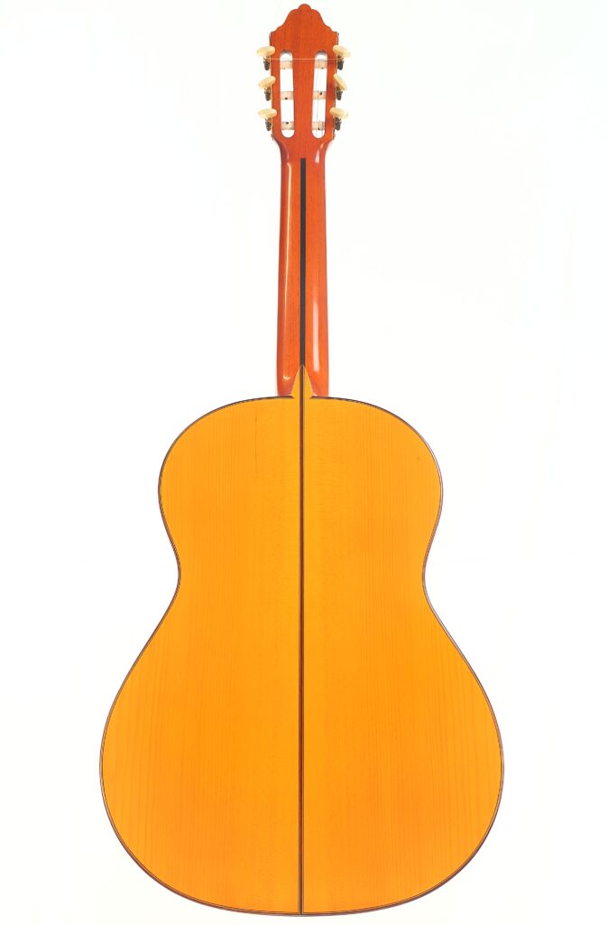 Eine Juan Montero 1993 Blanca Flamenco-Gitarre, von hinten fotografiert, mit poliertem Holzkorpus und -hals vor einem weißen Hintergrund. Eine Juan Montero 1993 Blanca Flamenco-Gitarre, von hinten fotografiert, mit poliertem Holzkorpus und -hals vor einem weißen Hintergrund.