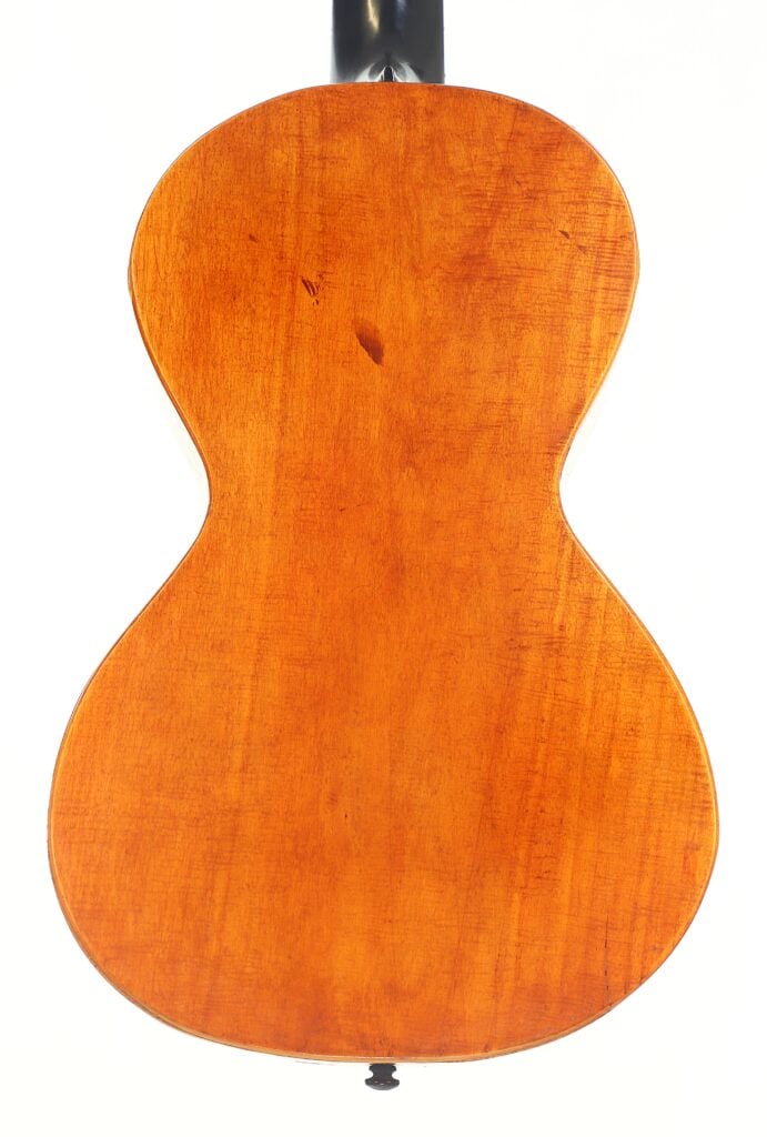 Die Rückseite der „Romantikgitarre“ von Stephan Thumhart aus dem Jahr 1838 weist eine glatte, warmbraune Holzoberfläche mit sichtbarer Maserung und einem leichten Glanz auf; das Foto wurde vor weißem Hintergrund aufgenommen. Die Rückseite der „Romantikgitarre“ von Stephan Thumhart aus dem Jahr 1838 weist eine glatte, warmbraune Holzoberfläche mit sichtbarer Maserung und einem leichten Glanz auf; das Foto wurde vor weißem Hintergrund aufgenommen.