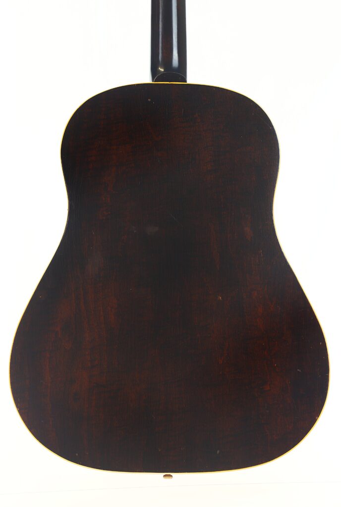 Das Bild zeigt die Rückansicht der Gibson J-45 Banner 1944 Akustik Gitarre mit ihrer dunklen Holzoberfläche und ihrer sanft gerundeten rechteckigen Form vor einem weißen Hintergrund. Das Bild zeigt die Rückansicht der Gibson J-45 Banner 1944 Akustik Gitarre mit ihrer dunklen Holzoberfläche und ihrer sanft gerundeten rechteckigen Form vor einem weißen Hintergrund.