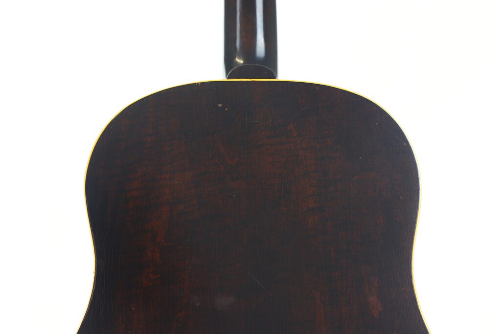 Das Bild zeigt die Rückseite einer Gibson J-45 Banner 1944 Akustik Gitarre in dunkelbraun mit glänzender Oberfläche und dezenter Holzmaserung, vor einem schlichten weißen Hintergrund. Das Bild zeigt die Rückseite einer Gibson J-45 Banner 1944 Akustik Gitarre in dunkelbraun mit glänzender Oberfläche und dezenter Holzmaserung, vor einem schlichten weißen Hintergrund.