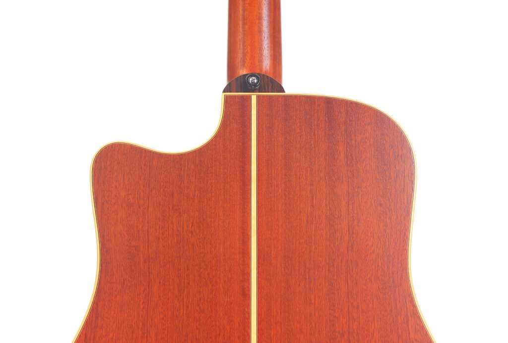 Nahaufnahme der Rückseite der Lakewood D-14-12 Cut 2005 Akustik-Gitarre, die ein Holzfinish, eine sichtbare Halsverbindung und einen zentralen vertikalen Streifen aus hellerem Holz aufweist. Nahaufnahme der Rückseite der Lakewood D-14-12 Cut 2005 Akustik-Gitarre, die ein Holzfinish, eine sichtbare Halsverbindung und einen zentralen vertikalen Streifen aus hellerem Holz aufweist.
