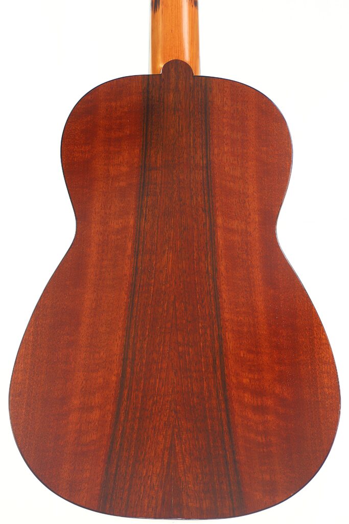 Die Rückseite der Andres Marin 1890 Klassische Gitarre zeigt eine polierte, rötlich-braune Holzmaserung mit einem dunklen Mittelstreifen, fotografiert vor einem weißen Hintergrund. Die Rückseite der Andres Marin 1890 Klassische Gitarre zeigt eine polierte, rötlich-braune Holzmaserung mit einem dunklen Mittelstreifen, fotografiert vor einem weißen Hintergrund.