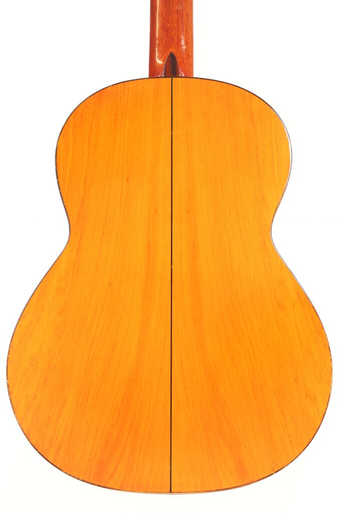 Die Rückseite der Conde Hermanos 1990 FelipeV N2 Flamenco-Gitarre aus hellem Holz mit sichtbarer Maserung ist vor einem weißen Hintergrund abgebildet. Eine dünne schwarze Linie verläuft vertikal in der Mitte und teilt die Rückseite in zwei Hälften. Die Rückseite der Conde Hermanos 1990 FelipeV N2 Flamenco-Gitarre aus hellem Holz mit sichtbarer Maserung ist vor einem weißen Hintergrund abgebildet. Eine dünne schwarze Linie verläuft vertikal in der Mitte und teilt die Rückseite in zwei Hälften.