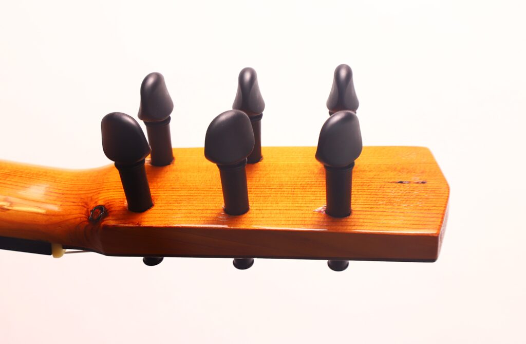 Nahaufnahme der Stimmwirbel auf der hölzernen Kopfplatte der Andres Marin 1890 Klassische Gitarre vor einem schlichten weißen Hintergrund. Nahaufnahme der Stimmwirbel auf der hölzernen Kopfplatte der Andres Marin 1890 Klassische Gitarre vor einem schlichten weißen Hintergrund.