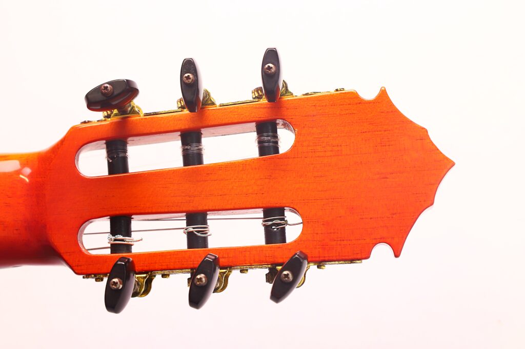 Nahaufnahme des Kopfes einer José M Palmero 2023 Flamenco-Gitarre, auf der die Stimmwirbel und Saiten vor weißem Hintergrund zu sehen sind. Nahaufnahme des Kopfes einer José M Palmero 2023 Flamenco-Gitarre, auf der die Stimmwirbel und Saiten vor weißem Hintergrund zu sehen sind.
