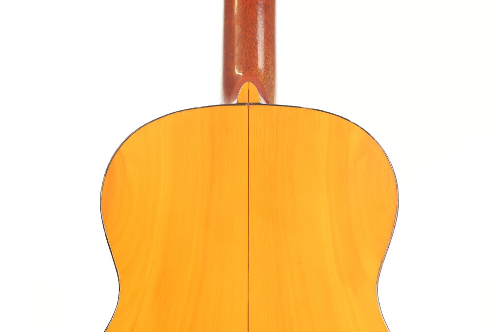 Das Bild zeigt die Rückseite einer Ricardo Sanchis Nacher 1940 Flamenco-Gitarre mit einer hellen Holzoberfläche auf weißem Hintergrund, mit dem sichtbaren Hals oben. Das Bild zeigt die Rückseite einer Ricardo Sanchis Nacher 1940 Flamenco-Gitarre mit einer hellen Holzoberfläche auf weißem Hintergrund, mit dem sichtbaren Hals oben.
