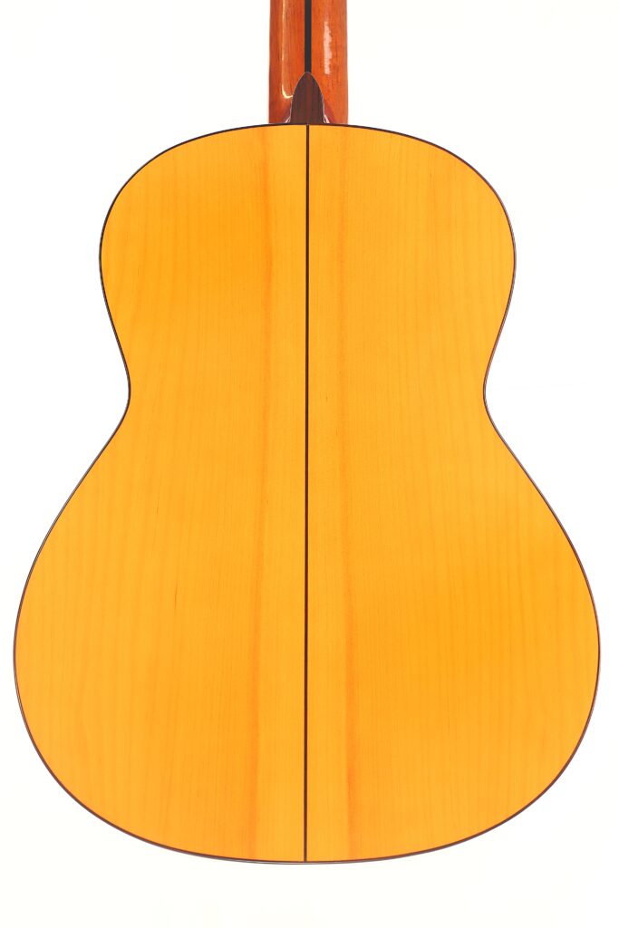 Das Bild zeigt die Rückseite einer Flamenco-Gitarre von Antonio Bernal aus dem Jahr 2009 mit heller Holzoberfläche, dunkler Mittelnaht und einer geschmeidigen, symmetrischen Form vor einem schlichten weißen Hintergrund. Das Bild zeigt die Rückseite einer Flamenco-Gitarre von Antonio Bernal aus dem Jahr 2009 mit heller Holzoberfläche, dunkler Mittelnaht und einer geschmeidigen, symmetrischen Form vor einem schlichten weißen Hintergrund.