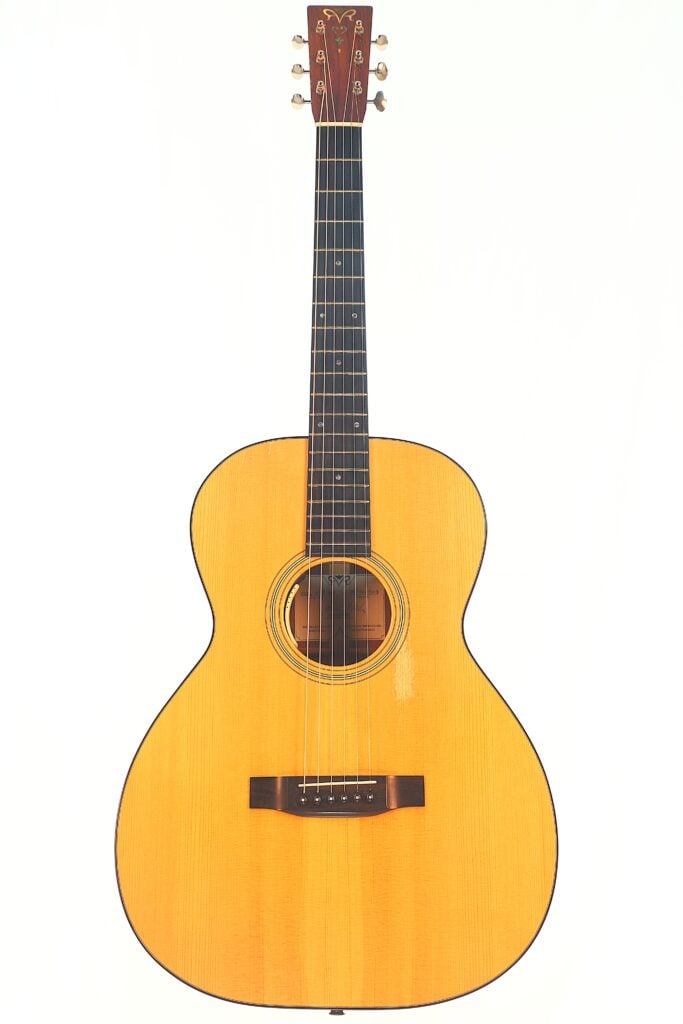 Die Rozawood 000 12-18-HM Akustikgitarre hat eine natürliche Holzoberfläche, einen abgerundeten Korpus, ein dunkles Griffbrett und sechs Saiten, die vor einem schlichten weißen Hintergrund abgebildet sind. Die Rozawood 000 12-18-HM Akustikgitarre hat eine natürliche Holzoberfläche, einen abgerundeten Korpus, ein dunkles Griffbrett und sechs Saiten, die vor einem schlichten weißen Hintergrund abgebildet sind.