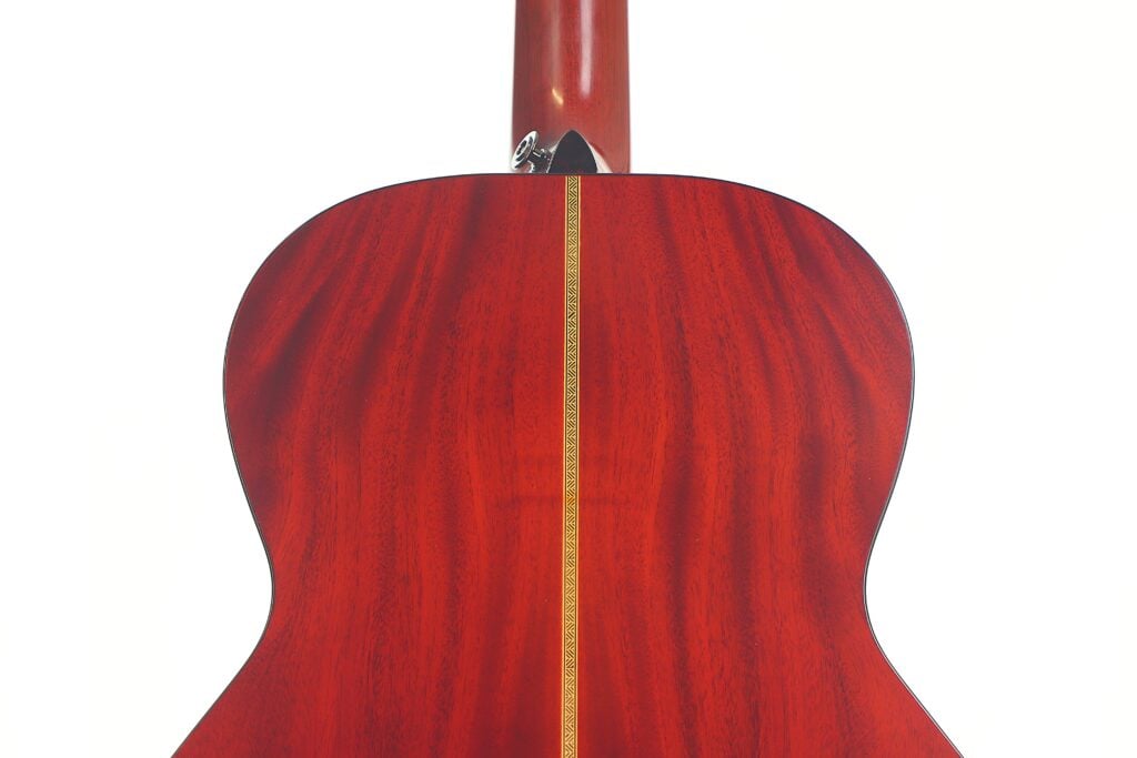 Das Bild zeigt die Rückseite der Rozawood 000 12-18-HM Akustik Gitarre mit einer polierten rötlichen Holzoberfläche und einem vertikalen Zierstreifen. Der Hals der Gitarre ist an der Oberseite teilweise sichtbar. Das Bild zeigt die Rückseite der Rozawood 000 12-18-HM Akustik Gitarre mit einer polierten rötlichen Holzoberfläche und einem vertikalen Zierstreifen. Der Hals der Gitarre ist an der Oberseite teilweise sichtbar.