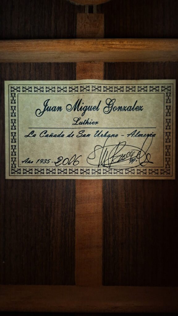 Die Innenseite einer Juan Miguel Gonzalez 2006 Klassische Gitarre ist mit einem Etikett versehen: "Juan Miguel Gonzalez, Luthier, La Cañada de San Urbano - Almería, Año 1935-2016", mit einer dekorativen Umrandung und Unterschrift. Die Innenseite einer Juan Miguel Gonzalez 2006 Klassische Gitarre ist mit einem Etikett versehen: "Juan Miguel Gonzalez, Luthier, La Cañada de San Urbano - Almería, Año 1935-2016", mit einer dekorativen Umrandung und Unterschrift.