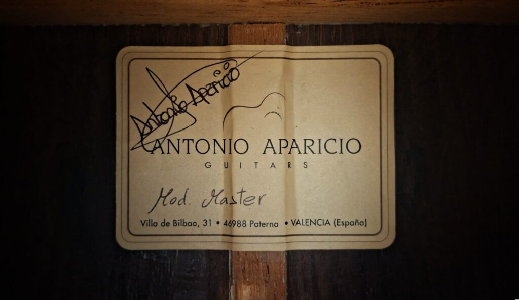 Das Etikett im Inneren der Gitarre lautet "Antonio Aparicio Mod. Master Klassische Gitarre, Villa de Bilbao, 31 - 46980 Paterna - Valencia (España)" und enthält eine Unterschrift in der oberen linken Ecke. Das Etikett im Inneren der Gitarre lautet "Antonio Aparicio Mod. Master Klassische Gitarre, Villa de Bilbao, 31 - 46980 Paterna - Valencia (España)" und enthält eine Unterschrift in der oberen linken Ecke.