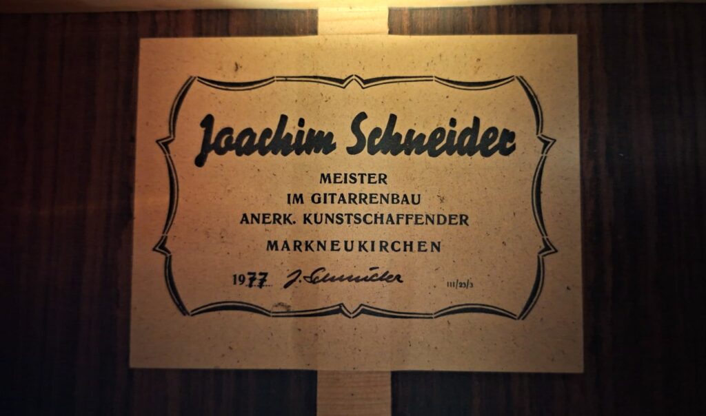 Im Inneren der „Joachim Schneider 1977 Klassische Gitarre“ befindet sich ein Etikett mit einer Zierbordüre, auf dem zu lesen ist: „Joachim Schneider, Meister im Gitarrenbau, Anerk. Kunstschaffender, Markneukirchen, 1977“, und das mit seiner Unterschrift versehen ist. Im Inneren der „Joachim Schneider 1977 Klassische Gitarre“ befindet sich ein Etikett mit einer Zierbordüre, auf dem zu lesen ist: „Joachim Schneider, Meister im Gitarrenbau, Anerk. Kunstschaffender, Markneukirchen, 1977“, und das mit seiner Unterschrift versehen ist.
