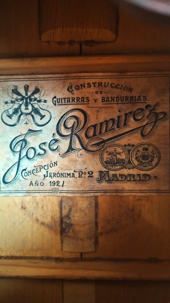 Die klassische Gitarre „José Ramírez I 1921“ verfügt über ein Vintage-Etikett mit der Aufschrift „José Ramírez, Construcción de Guitarras y Bandurrias, Concepción Jerónima Nr. 2, Madrid, Año 1921“, das mit dekorativen Motiven und zwei Siegeln verziert ist. Die klassische Gitarre „José Ramírez I 1921“ verfügt über ein Vintage-Etikett mit der Aufschrift „José Ramírez, Construcción de Guitarras y Bandurrias, Concepción Jerónima Nr. 2, Madrid, Año 1921“, das mit dekorativen Motiven und zwei Siegeln verziert ist.