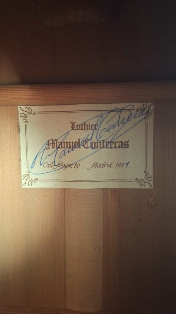 Im Inneren der „Doble Tapa Klassische Gitarre“ von Manuel Contreras aus dem Jahr 1981 befindet sich ein Etikett mit der Aufschrift: „Luthier Manuel Contreras, Calle Mayor 80, Madrid, 1981“, versehen mit einer großen blauen Unterschrift und einer Zierbordüre. Im Inneren der „Doble Tapa Klassische Gitarre“ von Manuel Contreras aus dem Jahr 1981 befindet sich ein Etikett mit der Aufschrift: „Luthier Manuel Contreras, Calle Mayor 80, Madrid, 1981“, versehen mit einer großen blauen Unterschrift und einer Zierbordüre.