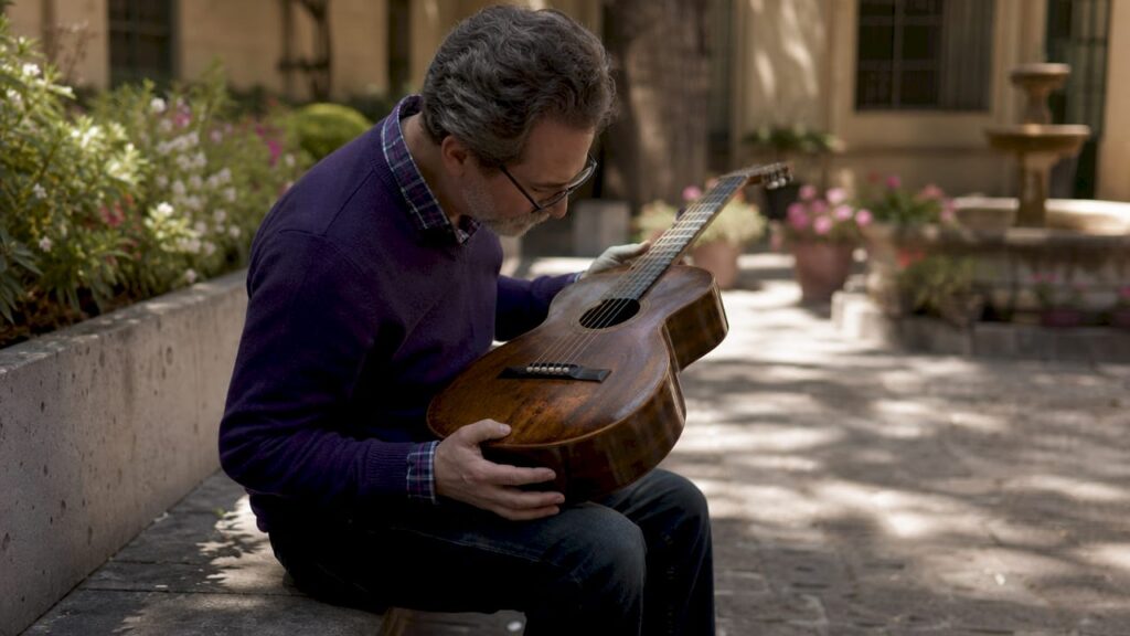Curator examining vintage museum guitar
