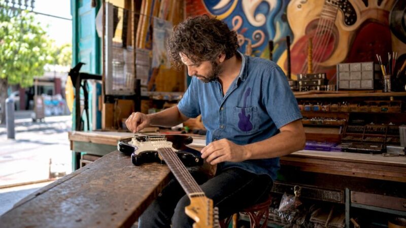 Technician adjusting electric guitar setup