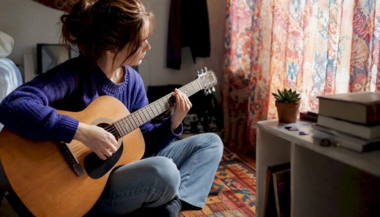 Beginner playing chords on acoustic guitar at home