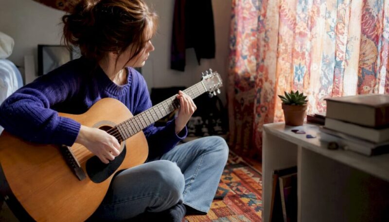 Beginner playing chords on acoustic guitar at home