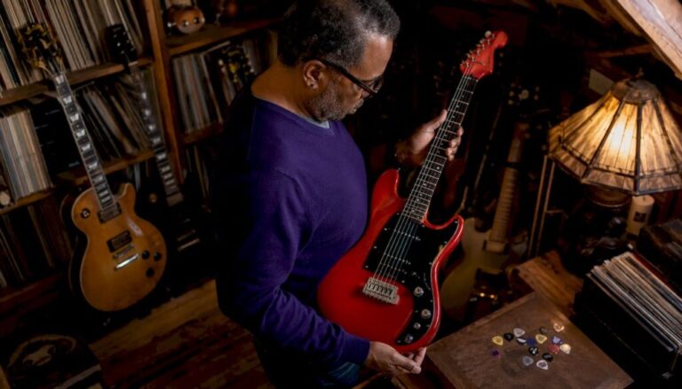 Collector examining vintage electric guitar in shop