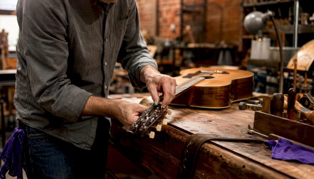 Hands tuning classical guitar during appraisal