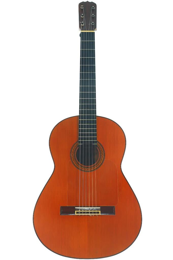 Eine Jose Ramirez 1a Flamenco-Gitarre aus dem Jahr 1968 mit einem rotbraunen Holzkorpus, sechs Saiten, einem schwarzen Griffbrett und Stimmwirbeln, dargestellt vor einem weißen Hintergrund. Eine Jose Ramirez 1a Flamenco-Gitarre aus dem Jahr 1968 mit einem rotbraunen Holzkorpus, sechs Saiten, einem schwarzen Griffbrett und Stimmwirbeln, dargestellt vor einem weißen Hintergrund.