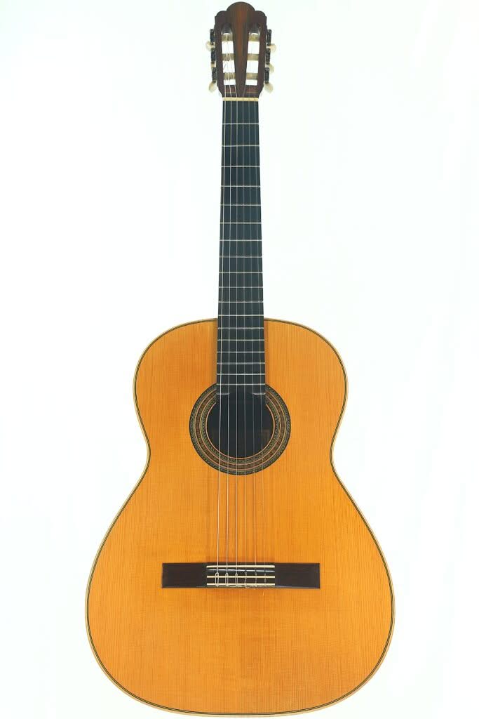 Die Alastair McNeil 1997 Hauser Klassische Gitarre, eine klassische Akustikgitarre mit einem Korpus aus Holz, sechs Saiten und einem dunklen Griffbrett, ist vor einem schlichten weißen Hintergrund fotografiert. Die Alastair McNeil 1997 Hauser Klassische Gitarre, eine klassische Akustikgitarre mit einem Korpus aus Holz, sechs Saiten und einem dunklen Griffbrett, ist vor einem schlichten weißen Hintergrund fotografiert.
